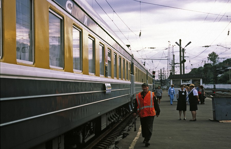trainbonking in omsk.jpg - The guy with the fluoro jacket walked along the side of the train with a metal rod and made a nice bonking noise by hitting all the wheel-caps. It happened every time the train stopped.  Not sure why though.